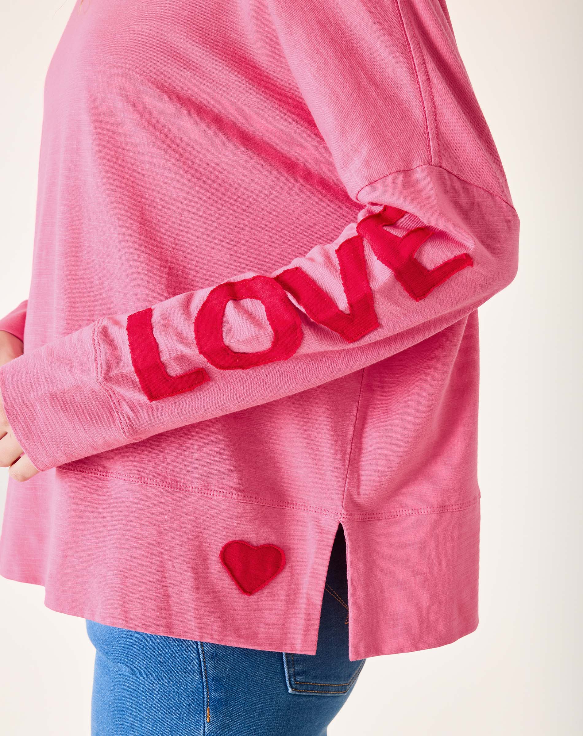 Pink sweatshirt with 'LOVE' and heart design on a white background