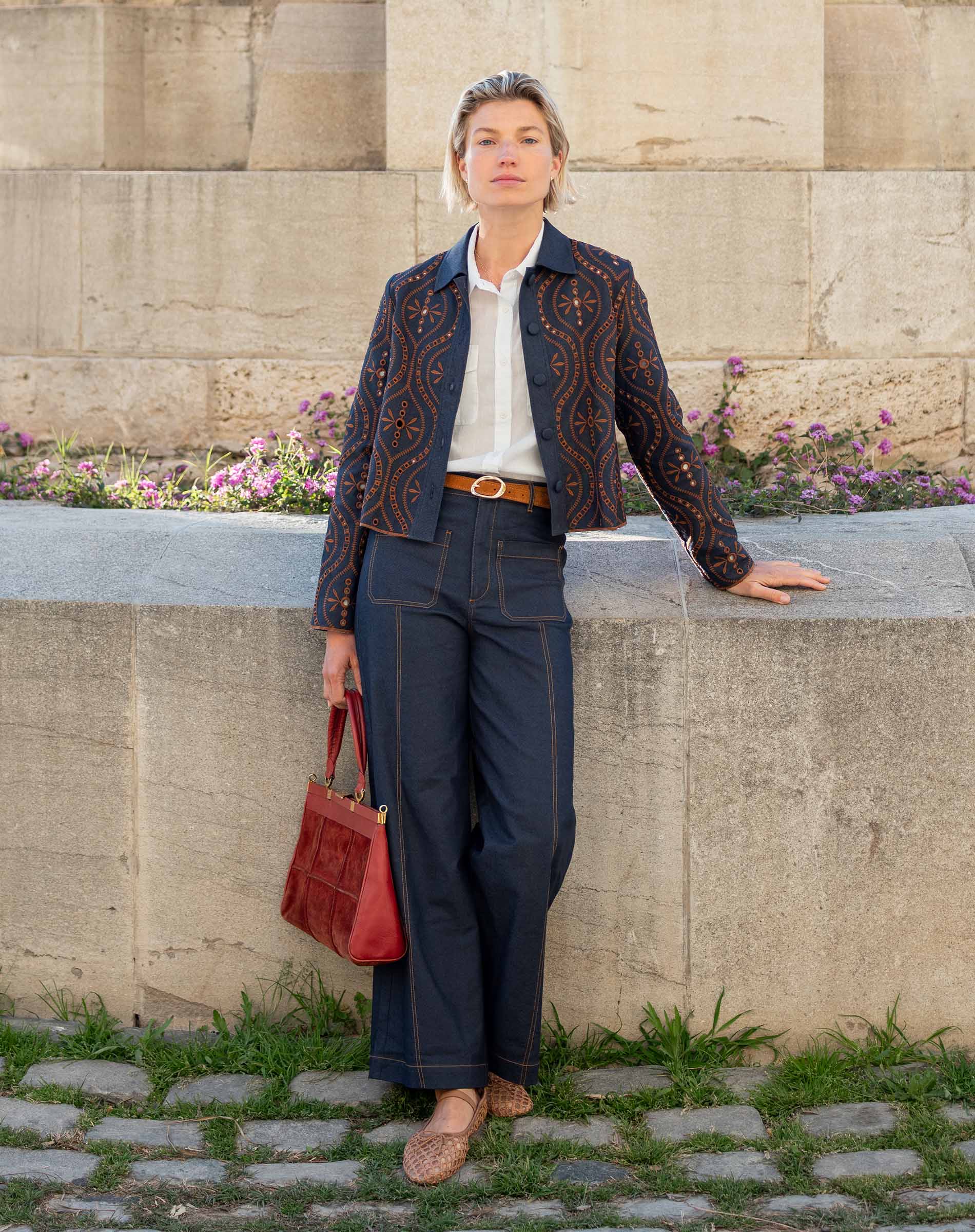 Navy blue woven pants with a subtle striped texture and wide legs.