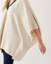 closeup of arm opening on woman wearing mersea Anywear v new poncho in birch beige with blue collar details