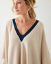 closeup of woman wearing mersea Anywear v new poncho in birch beige with blue collar details