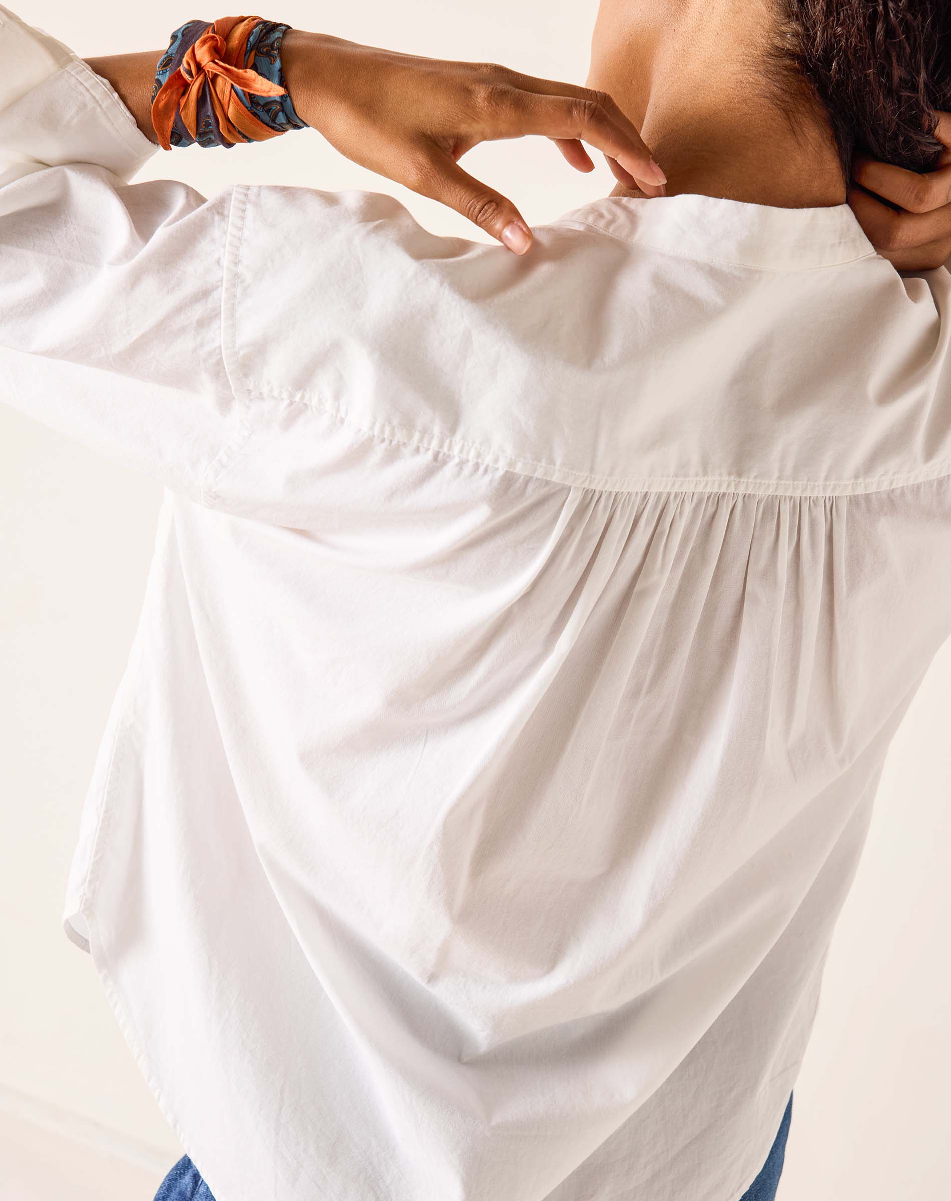 Close-up of a person wearing a white dress with a blurred background