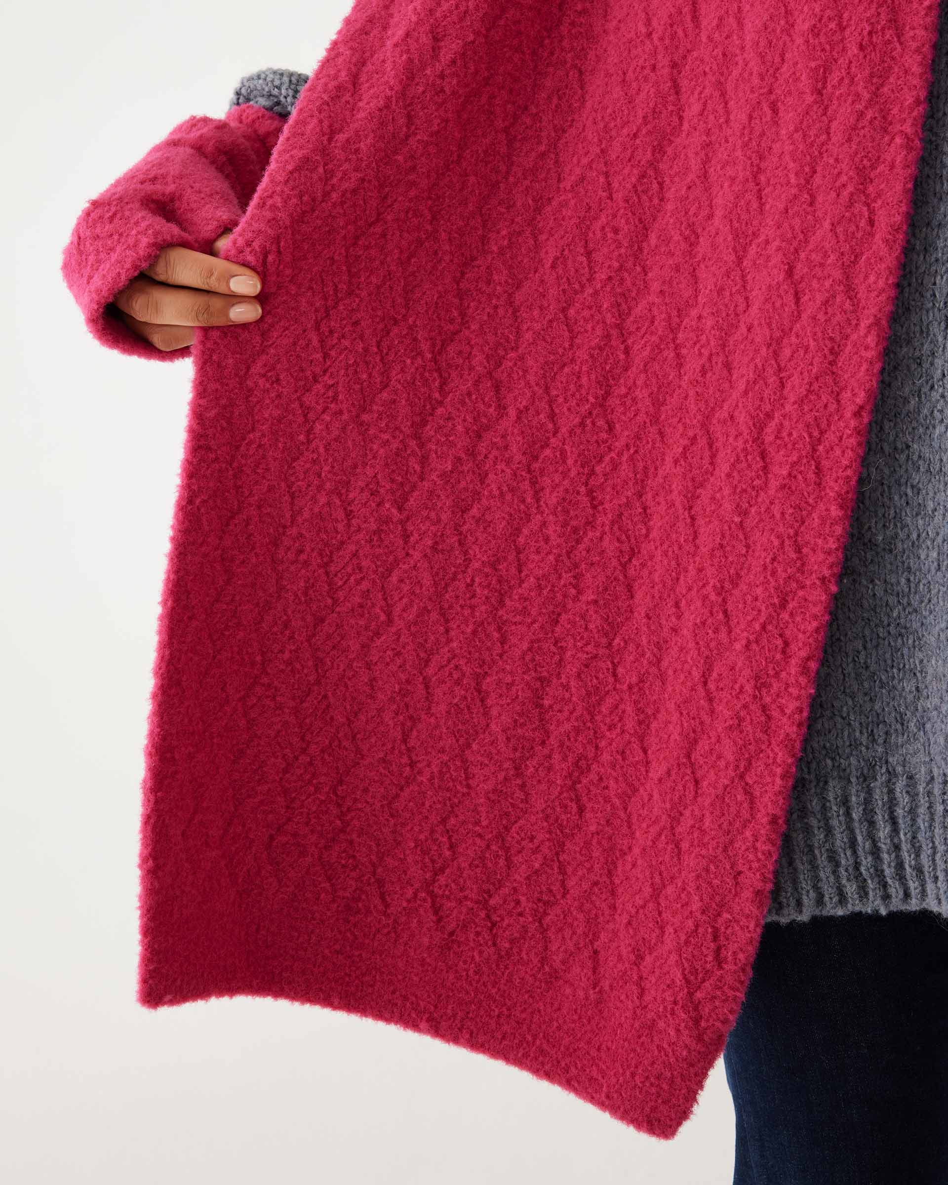 closeup of details of scarf on woman wearing mersea rasberry apres scarf and fingerless gloves