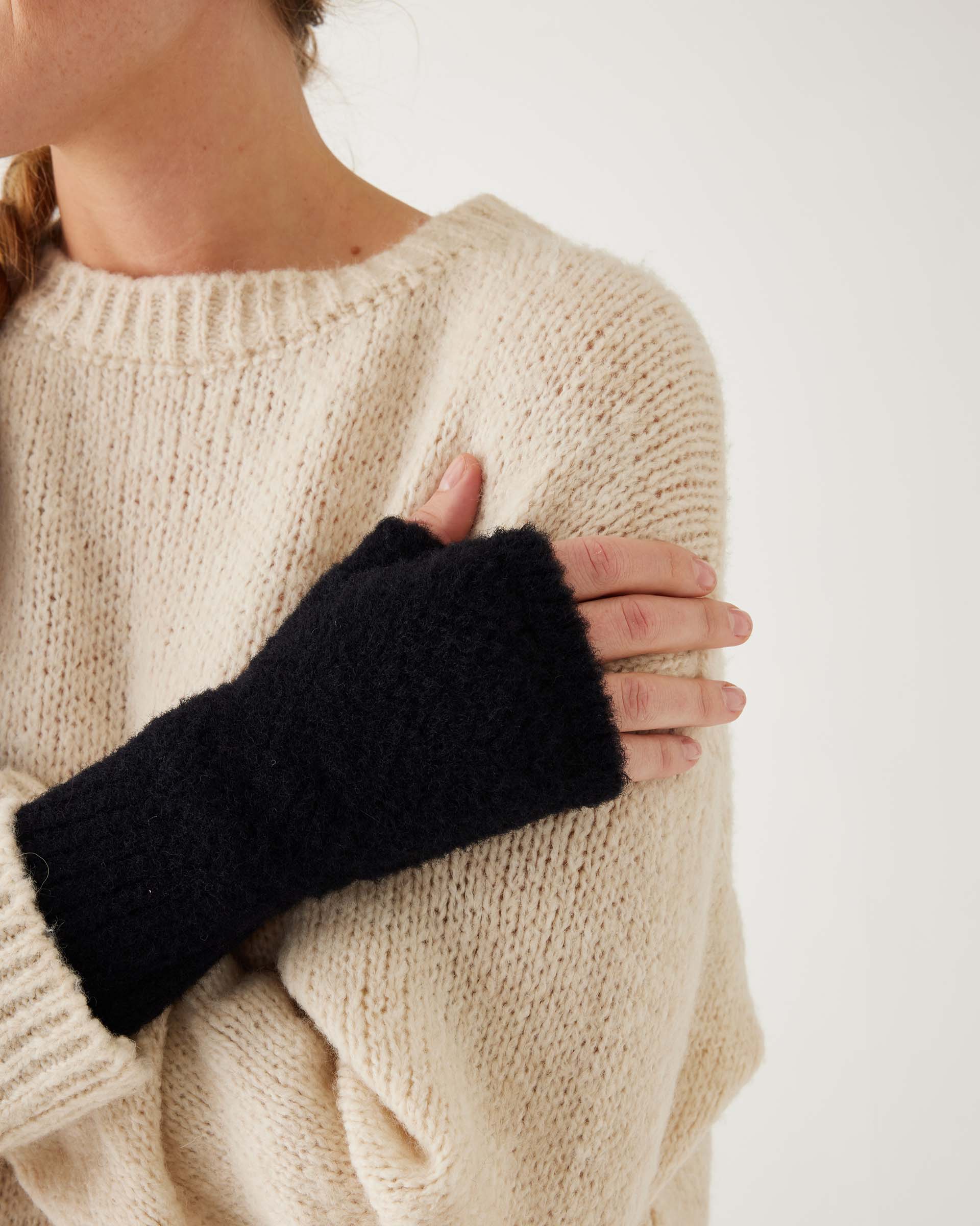 closeup of woman wearing mersea black apres fingerless gloves