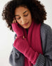 woman wearing mersea rasberry apres fingerless gloves and scarf