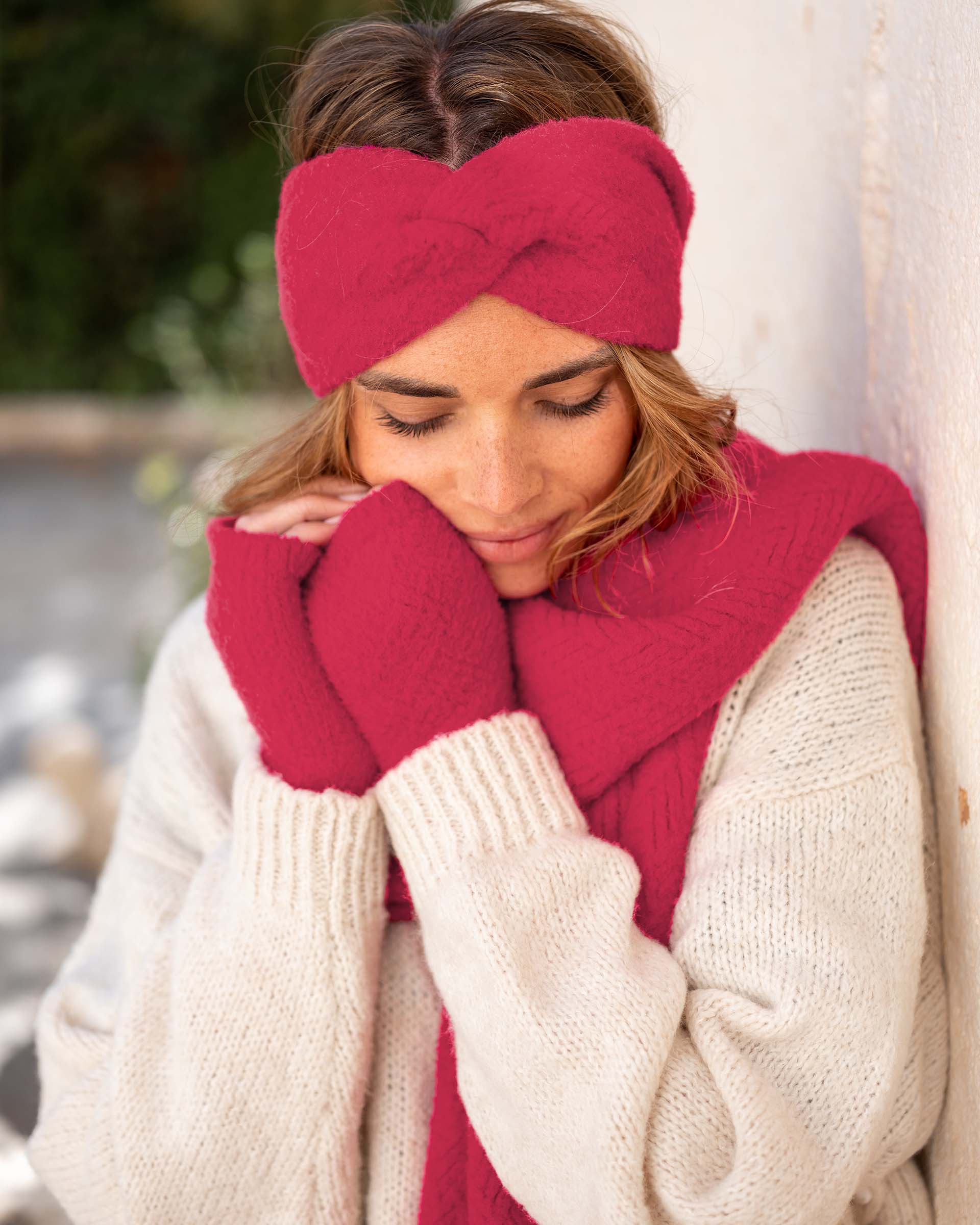 closeup of woman wearing mersea rasberry apres headband fingerless gloves and scarf