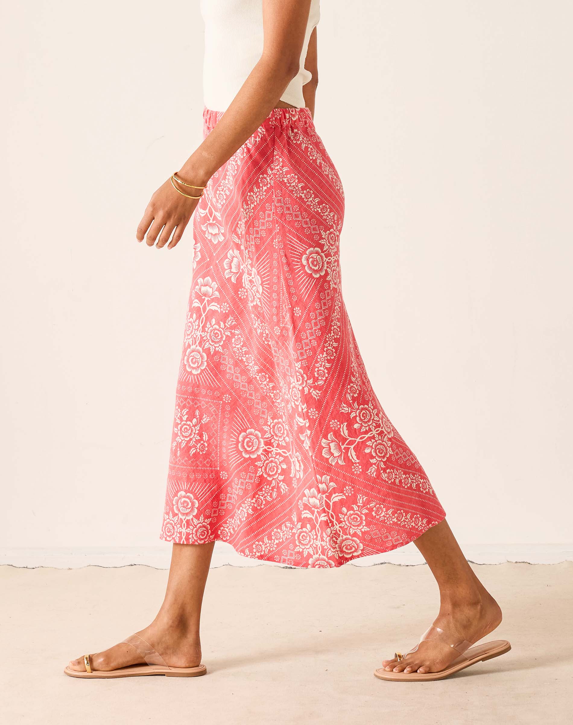 Person wearing a pink patterned skirt with white background