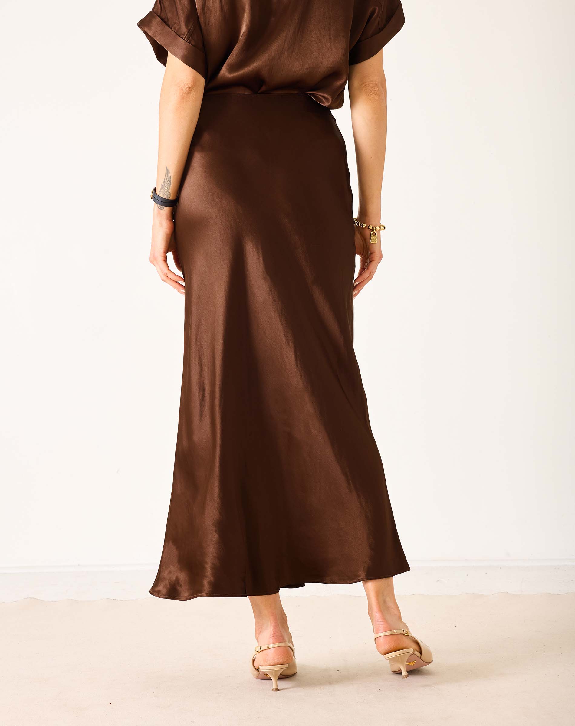 Chocolate brown satin midi skirt with a smooth, flowing finish.