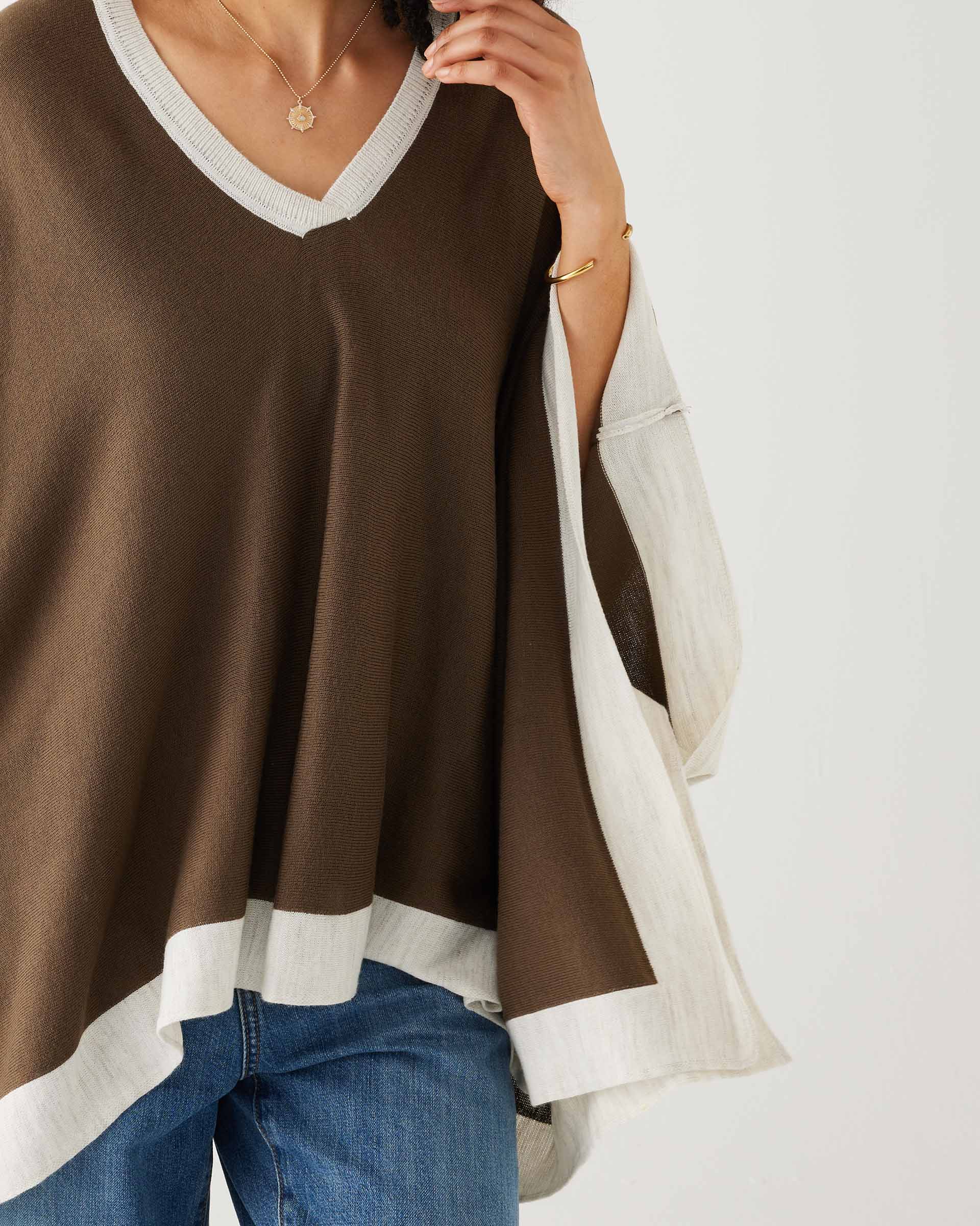 closeup of woman wearing mersea olive and sea salt avalon poncho