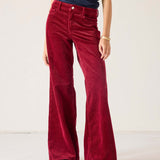 Red velvet pants worn by a person on a white background