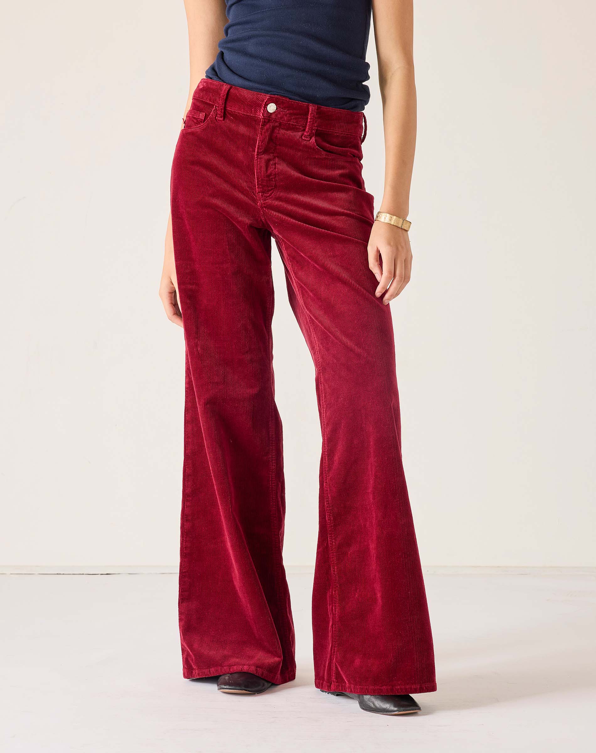 Red velvet pants worn by a person on a white background