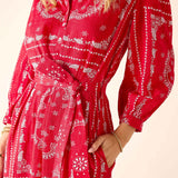 Red patterned dress worn by a person on a beige background