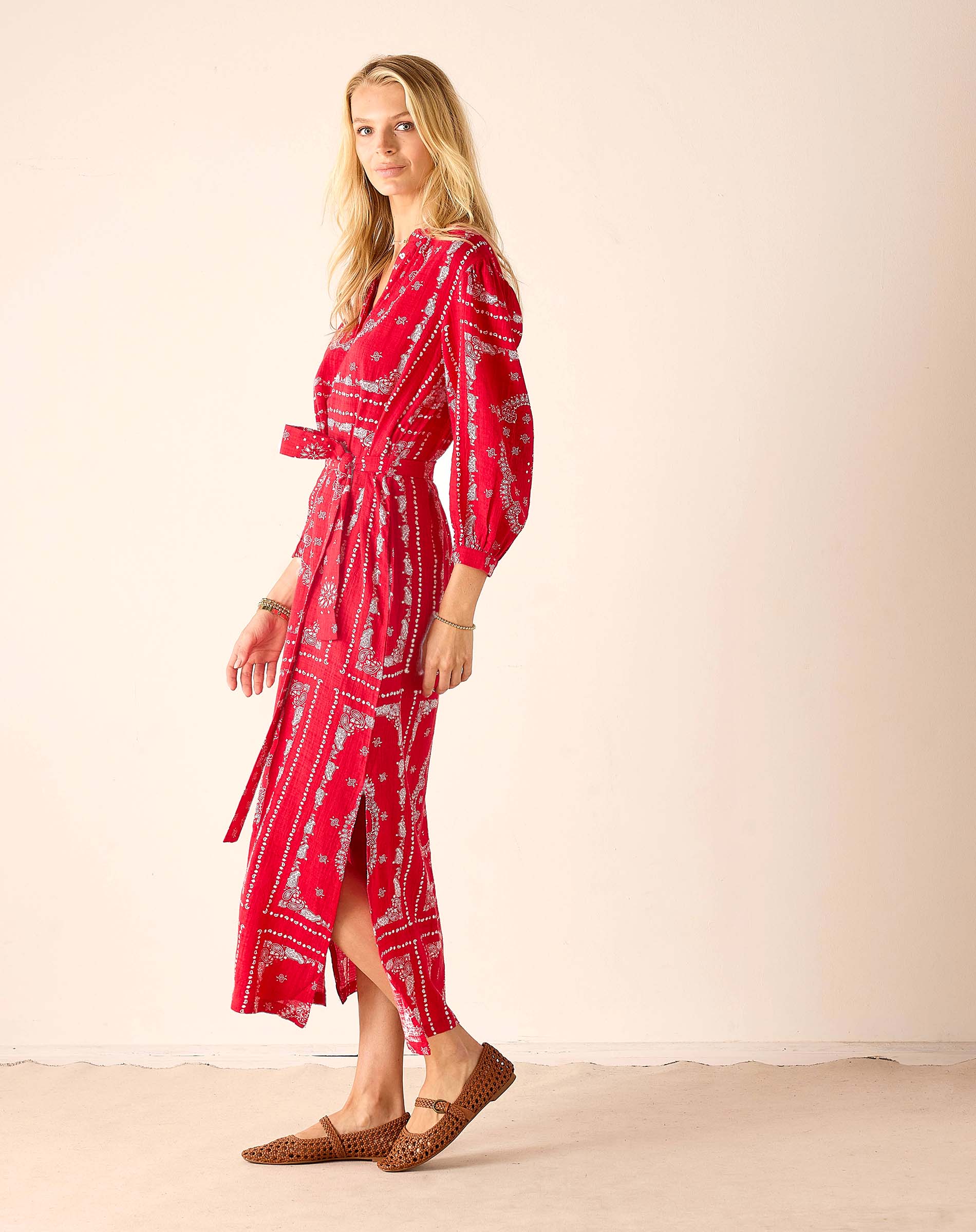 Woman wearing a red patterned dress with a plain background