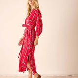Woman wearing a red patterned dress against a beige background