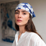 Woman wearing a blue patterned headscarf indoors