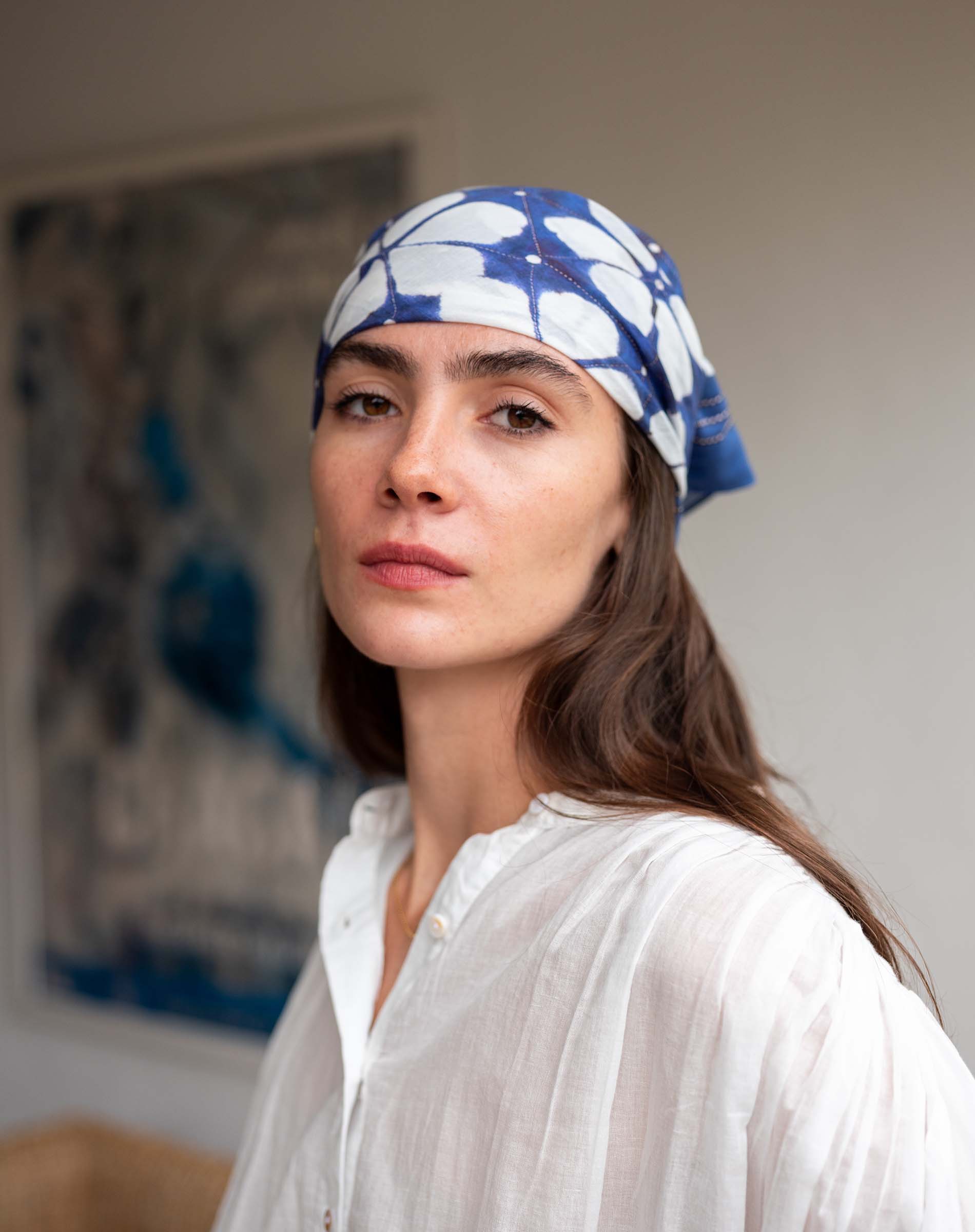 Woman wearing a blue patterned headscarf indoors