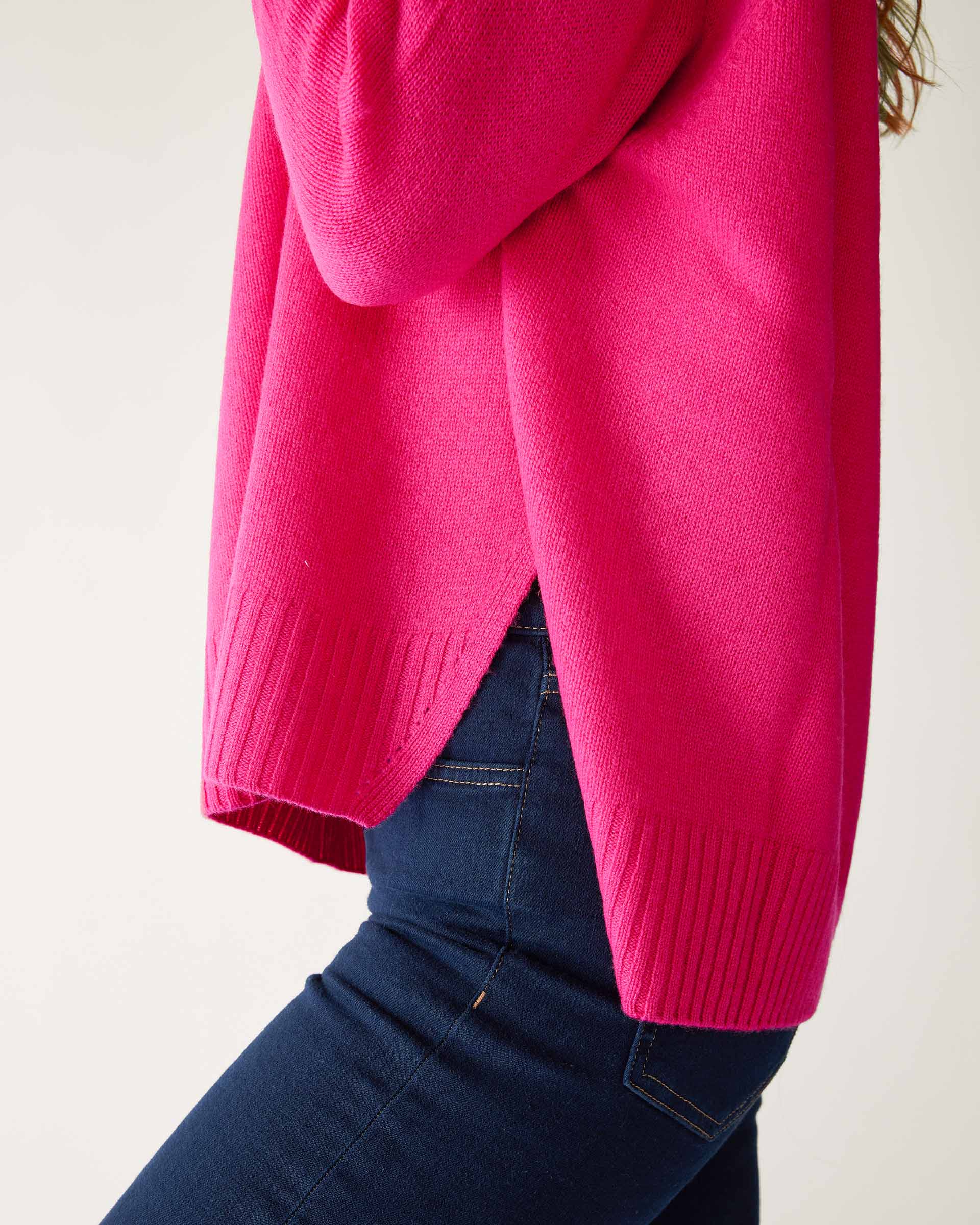 closeup of sweater side split on woman wearing mersea banff cashmere sweater in hot magenta