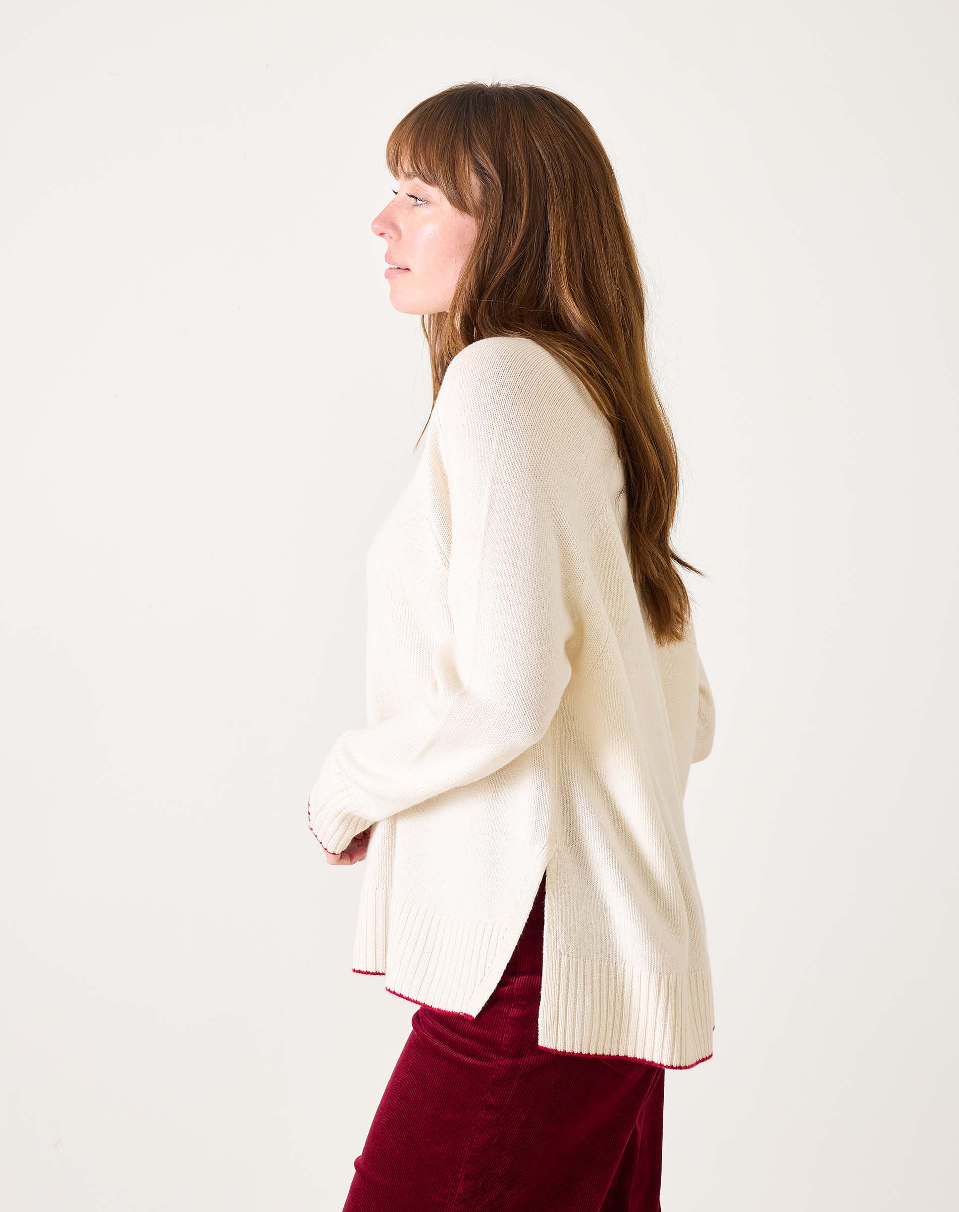 White sweater with red text 'La Rebel' worn by a person on a white background