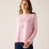 Woman wearing a pink sweater with a plain background