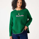 Green sweater with pink text 'Weekender' worn by a person on a white background