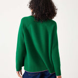Green sweater with pink text 'Weekender' worn by a person on a white background