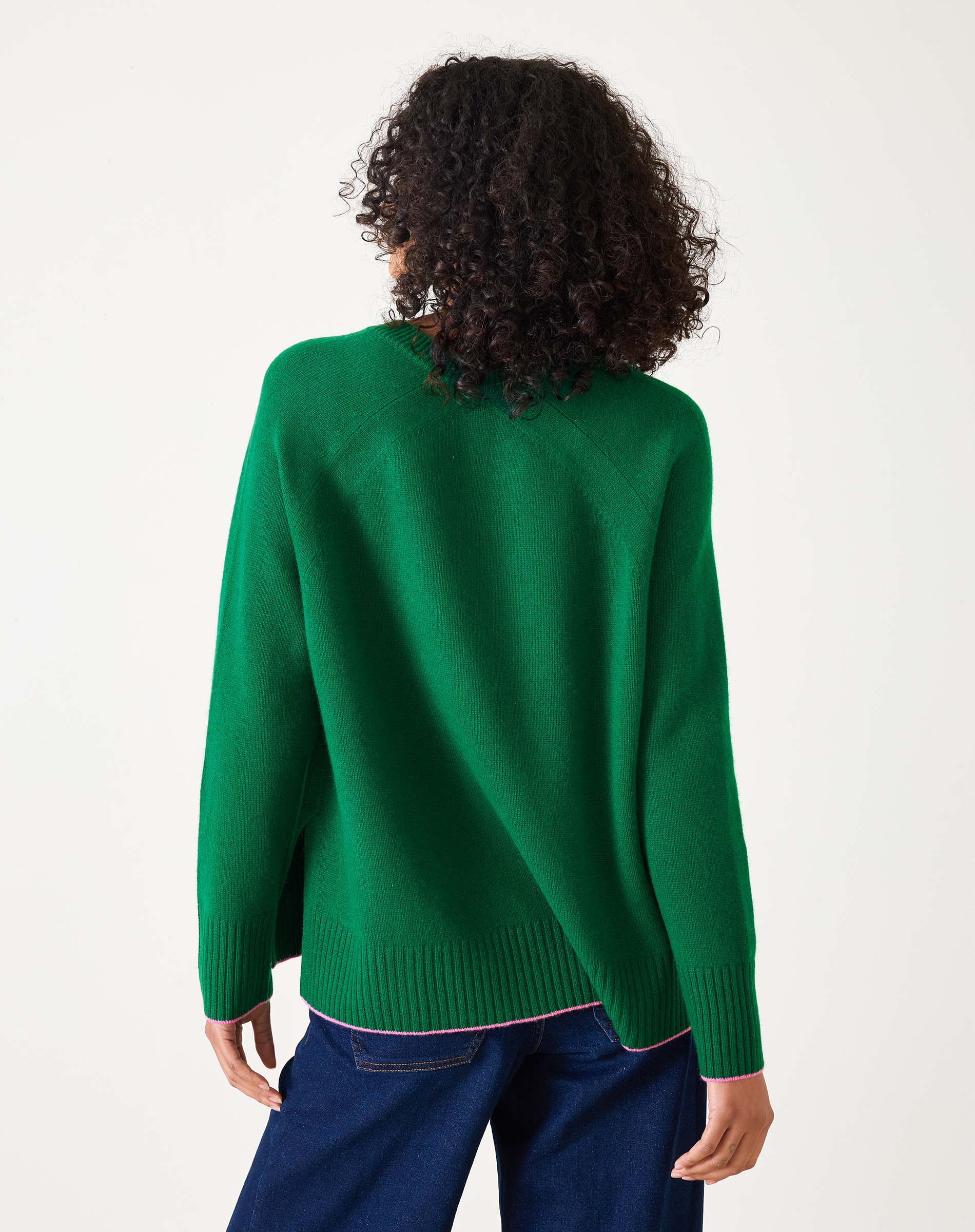 Green sweater with pink text 'Weekender' worn by a person on a white background