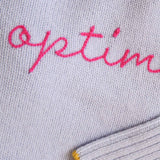 Gray fabric with pink embroidered text on a gray background
