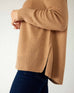 closeup of side on woman wearing mersea banff cashmere sweater in camel