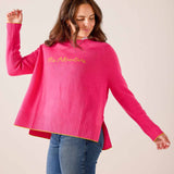 Hot pink oversized knit sweater with ribbed cuffs and hem, featuring 'Ms. Adventure' in gold script. Text: Ms. Adventure