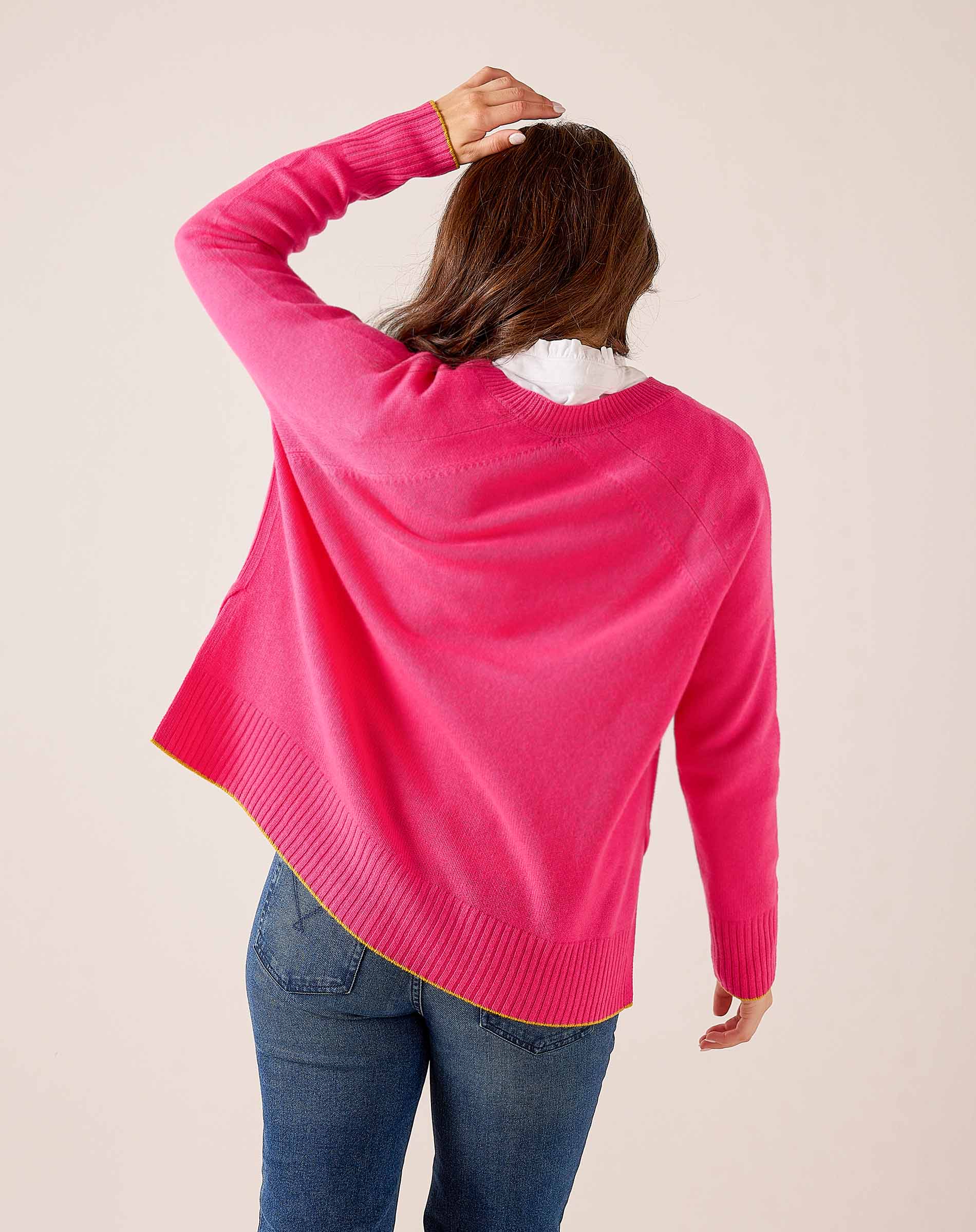 Back view of a vibrant pink knit sweater with ribbed hem and cuffs.