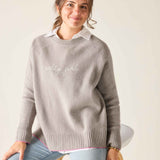 Woman wearing a gray sweater with 'sassy girl' text on a white background