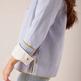 Sky blue knit sweater with white contrast cuffs and small star embroidery detail.