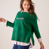 Emerald green knit sweater with ribbed hem and cuffs, styled over a white and pink striped button-down shirt. Text: weekender