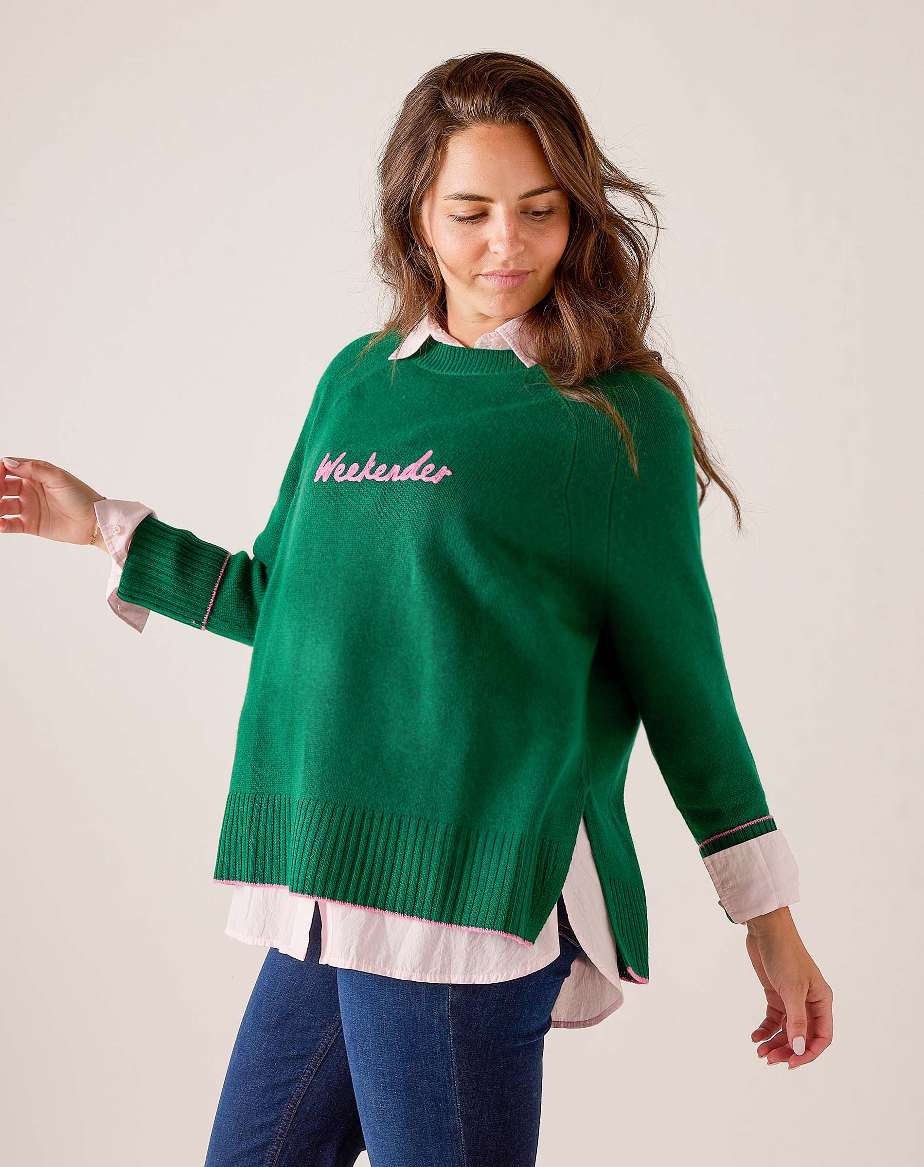 Emerald green knit sweater with ribbed hem and cuffs, styled over a white and pink striped button-down shirt. Text: weekender