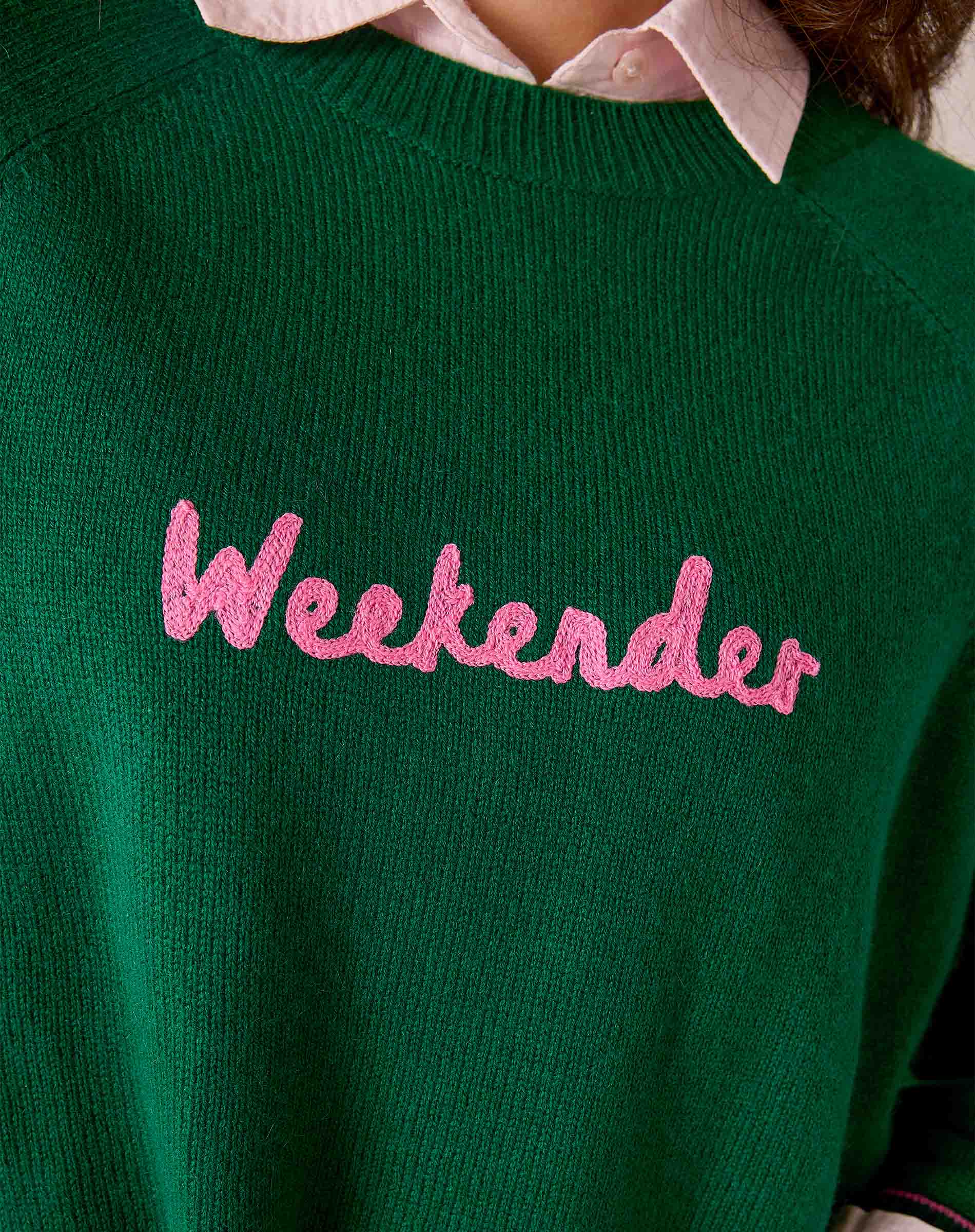 Forest green ribbed knit sweater with 'Weekenders' embroidered in pink. Text: Weekenders