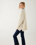 profile of woman wearing mersea bari side button buttercream sweater standing against white background