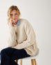 woman wearing mersea bari side button buttercream sweater sitting on stool