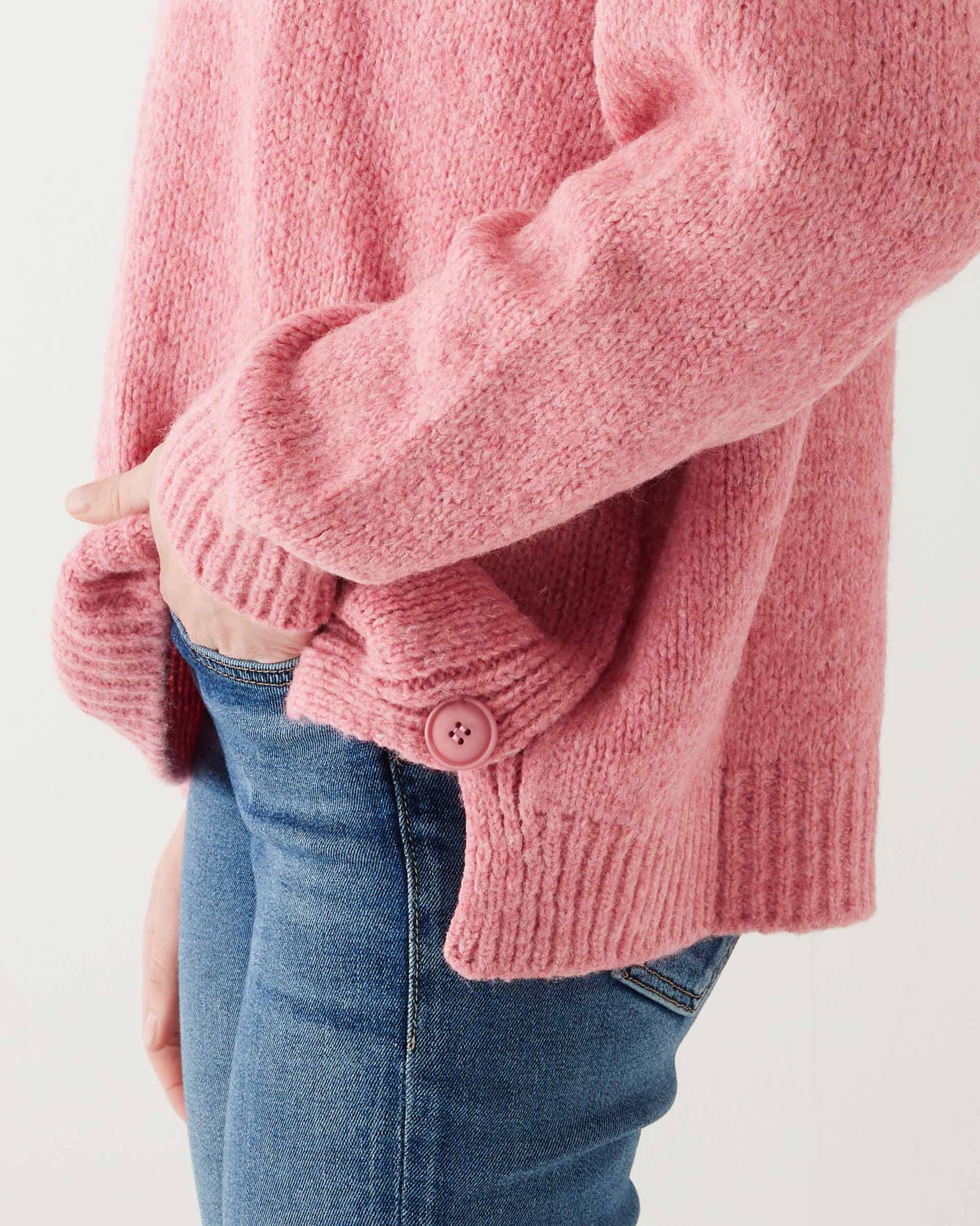 closeup of side buttons on woman wearing mersea bari side button rouge sweater standing with hand in pocket