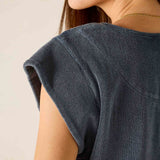 Close-up of a person wearing a dark denim shirt against a neutral background