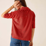 Back view of a woman's travel-friendly sunbaked orange terry cloth top with a classic collar and elbow-length sleeves.