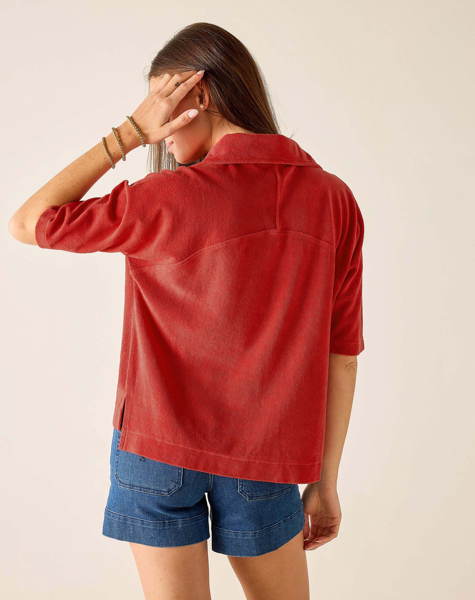 Back view of a woman's travel-friendly sunbaked orange terry cloth top with a classic collar and elbow-length sleeves.