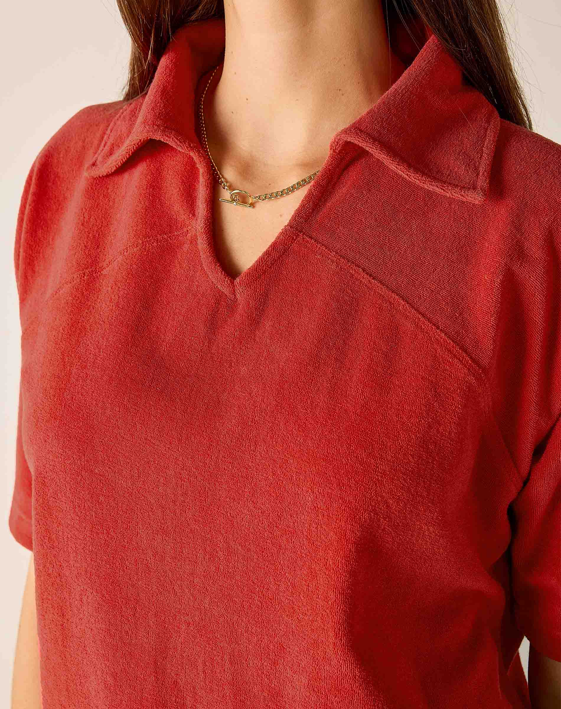 Sunbaked terracotta-colored terry cloth top with a collar and V-neckline.