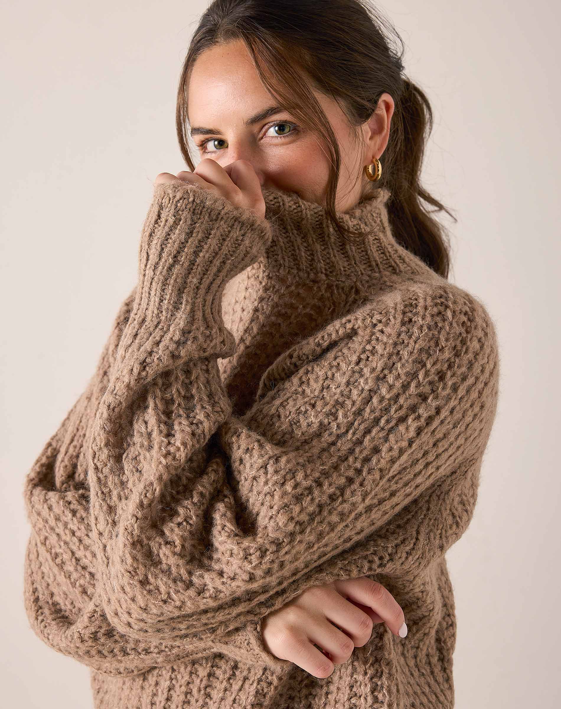Beachstone tan cable knit turtleneck sweater with ribbed cuffs and a cozy oversized fit