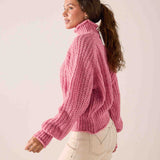 Soft pink ribbed knit sweater with a high turtleneck and balloon sleeves.