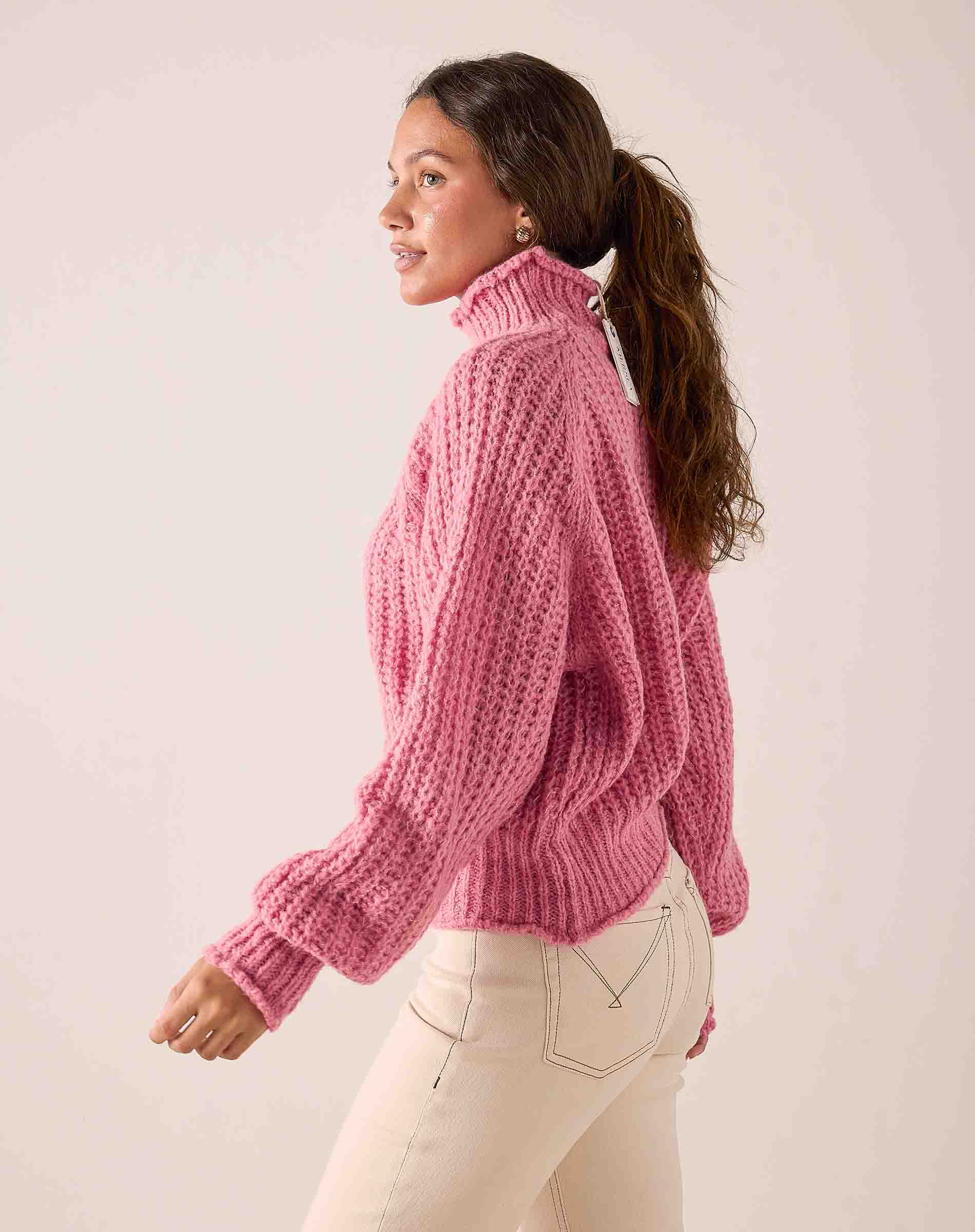 Soft pink ribbed knit sweater with a high turtleneck and balloon sleeves.