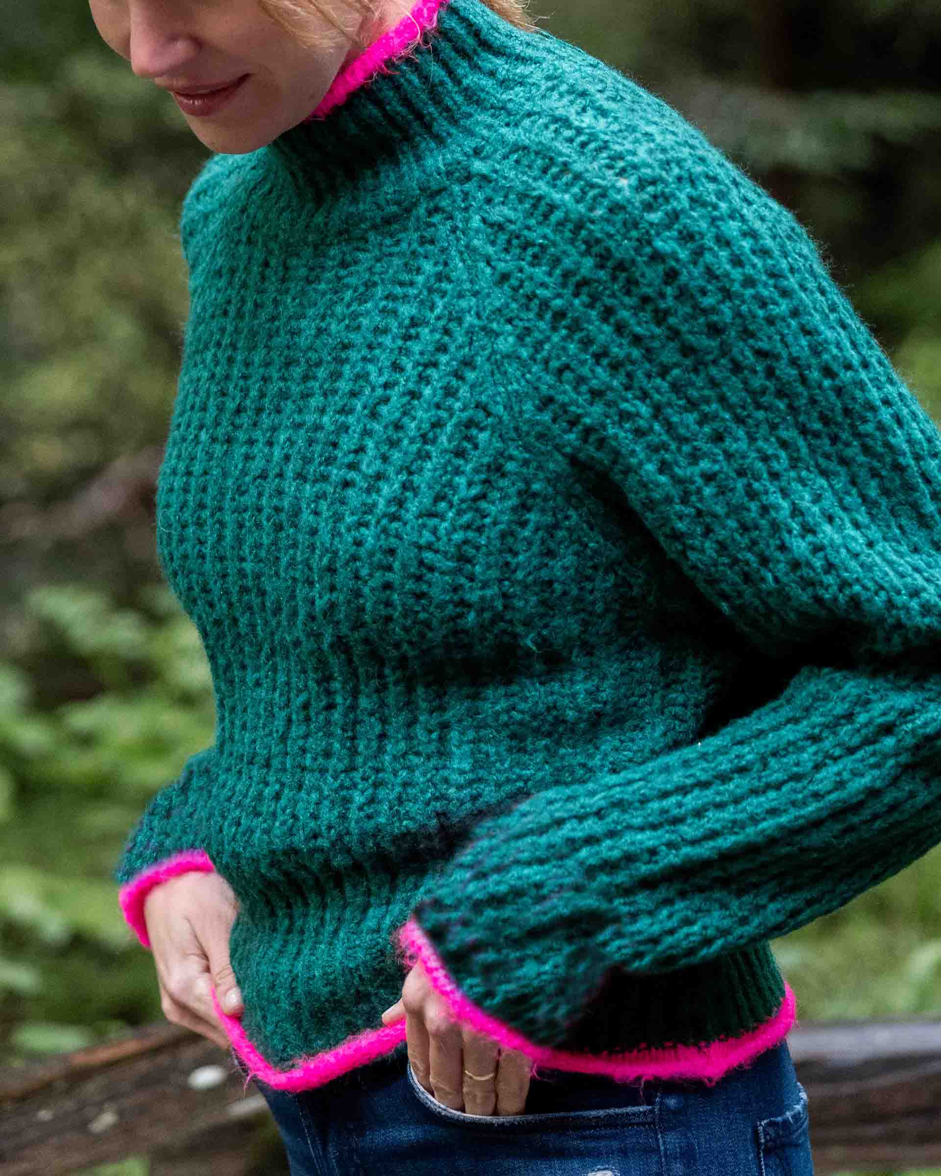 Bright emerald knit sweater with hot pink trim and ribbed texture.