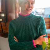 Emerald green ribbed knit sweater with pink trim.