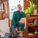 Emerald green textured knit sweater with pink trim and a ribbed hem.
