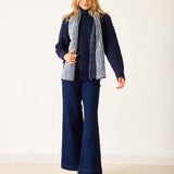 Navy blue ribbed knit sweater with a striped scarf.