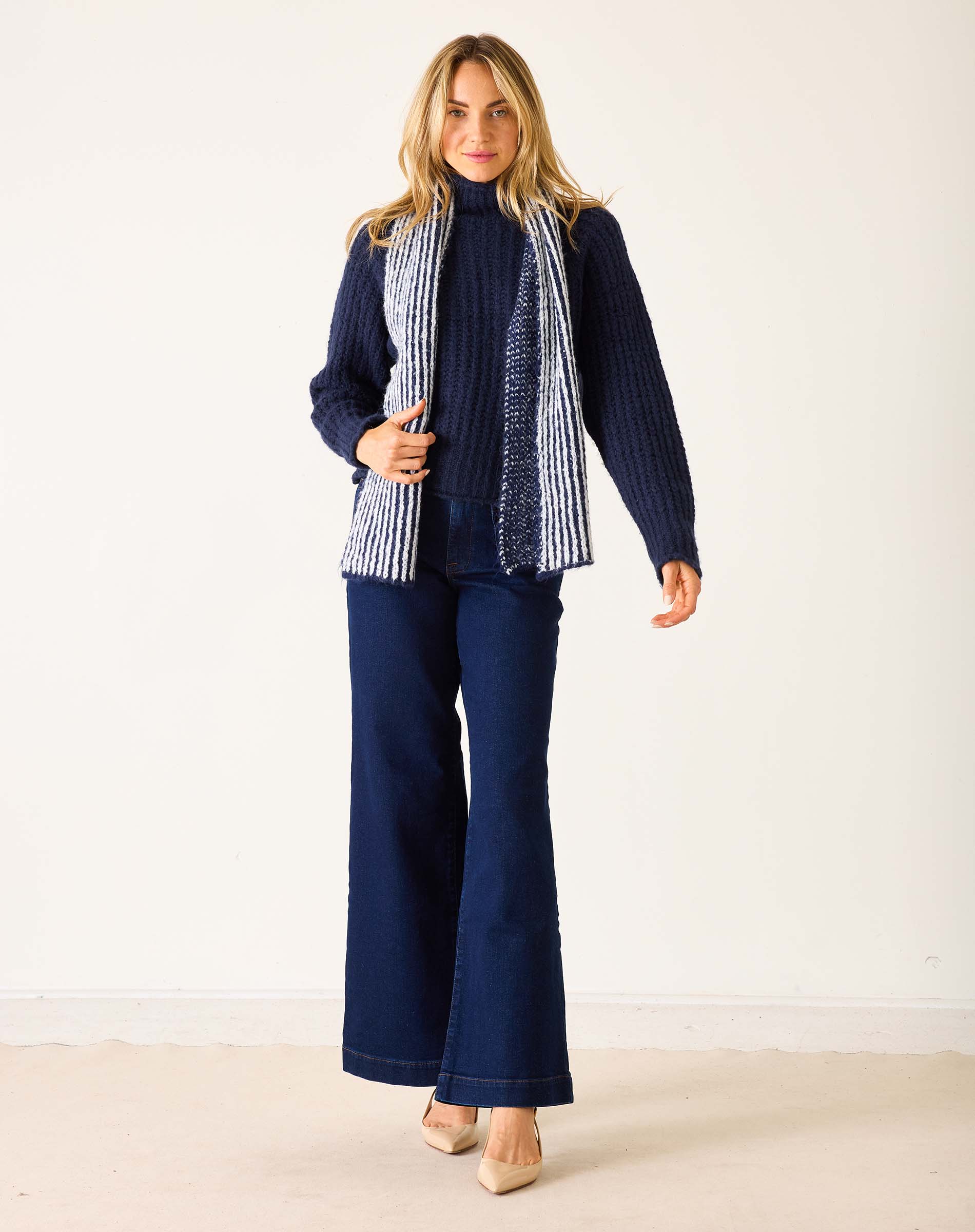 Navy blue ribbed knit sweater with a striped scarf.