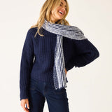 Navy blue ribbed knit sweater with a matching striped shawl draped over the shoulders.